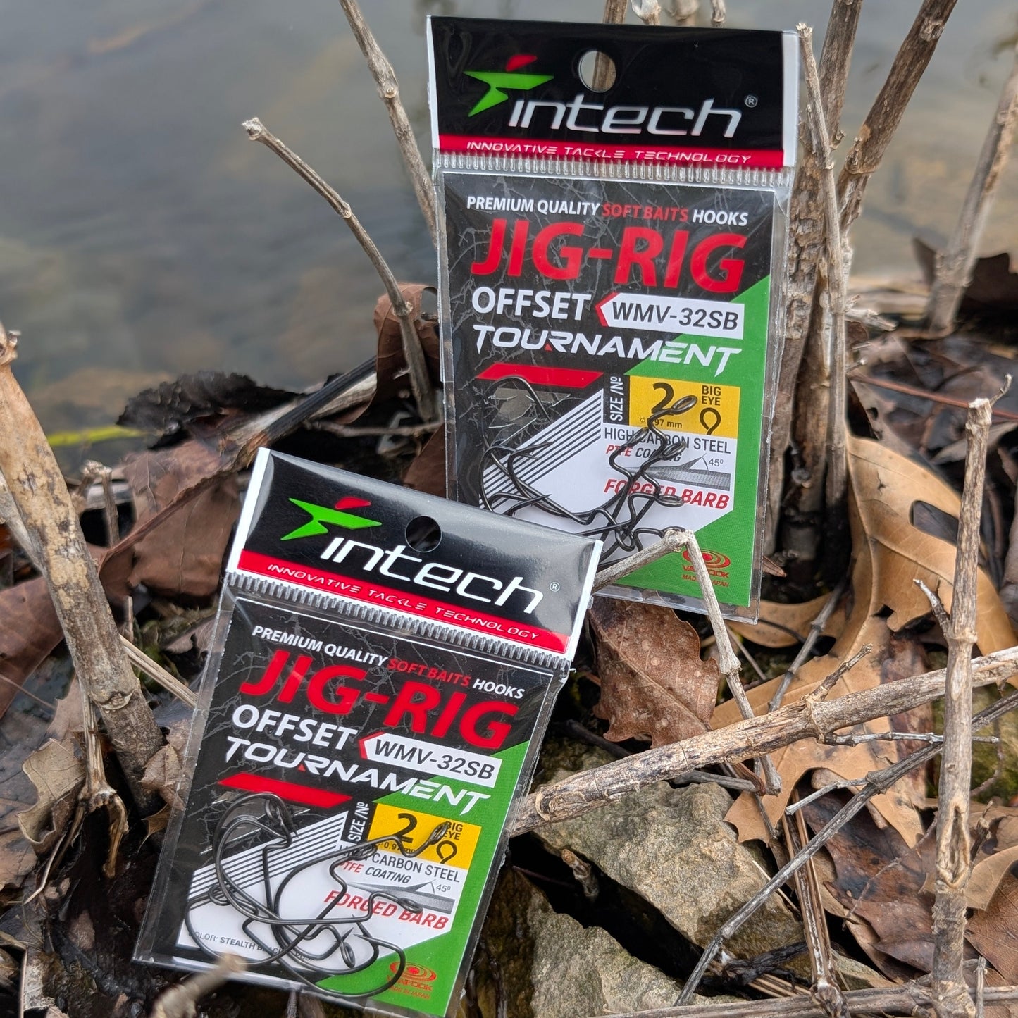 Two packages of Intech Jig-Rig Offset Tournament fishing hooks on a natural background with water and rocks.