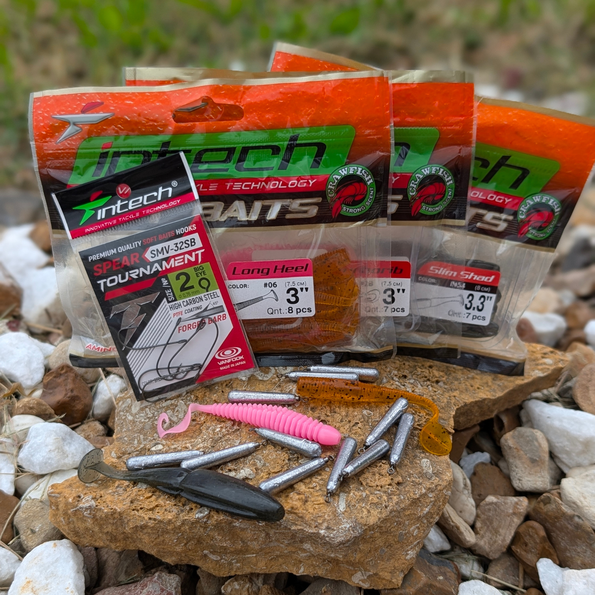 Intech soft bait packs, Tournament hooks, and cylindrical drop shot weights displayed on a rock outdoors.