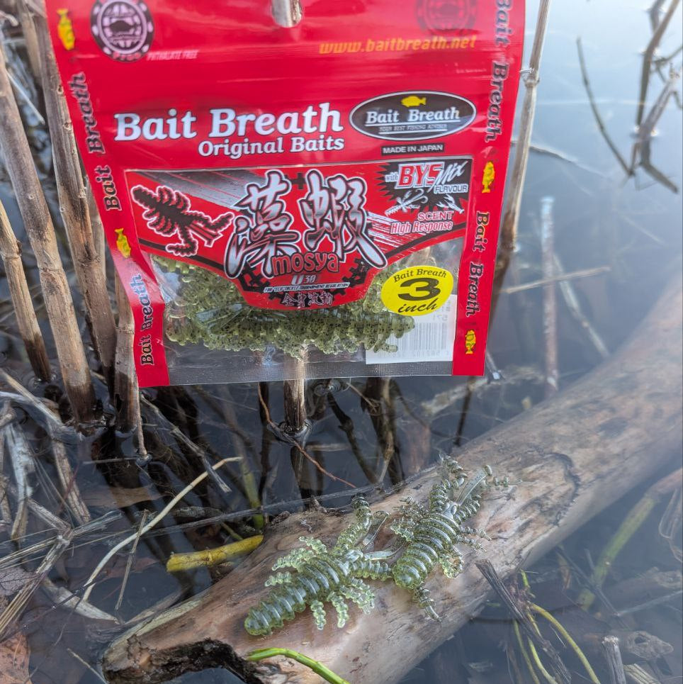 Bait Breath packaging on a log with water and reeds in the background