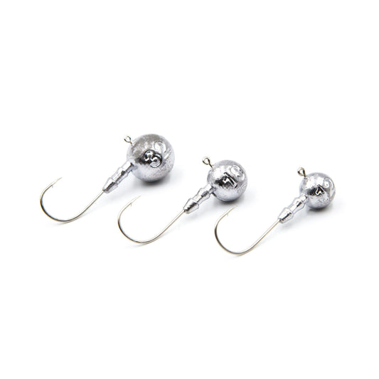 Three silver fishing jigs on a white background