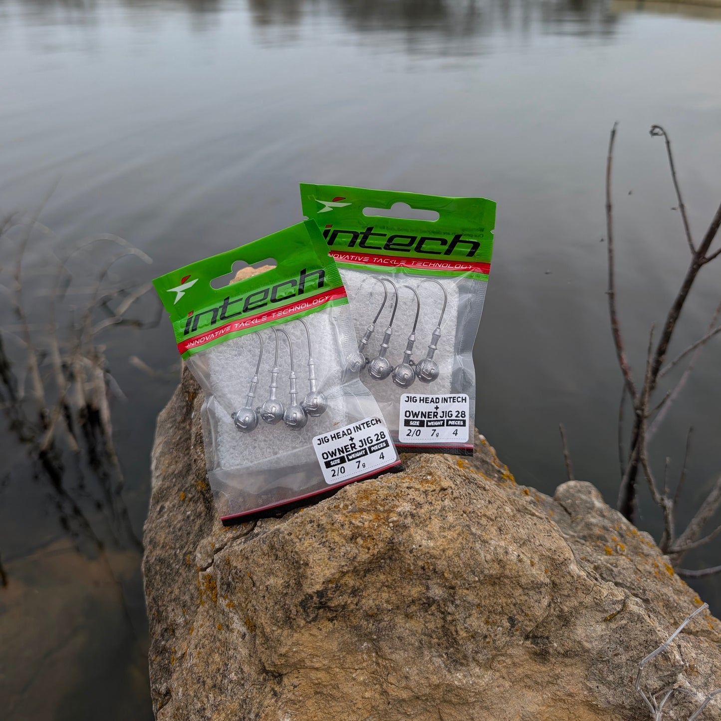Pack of Intech fishing hooks on a rock by a lake