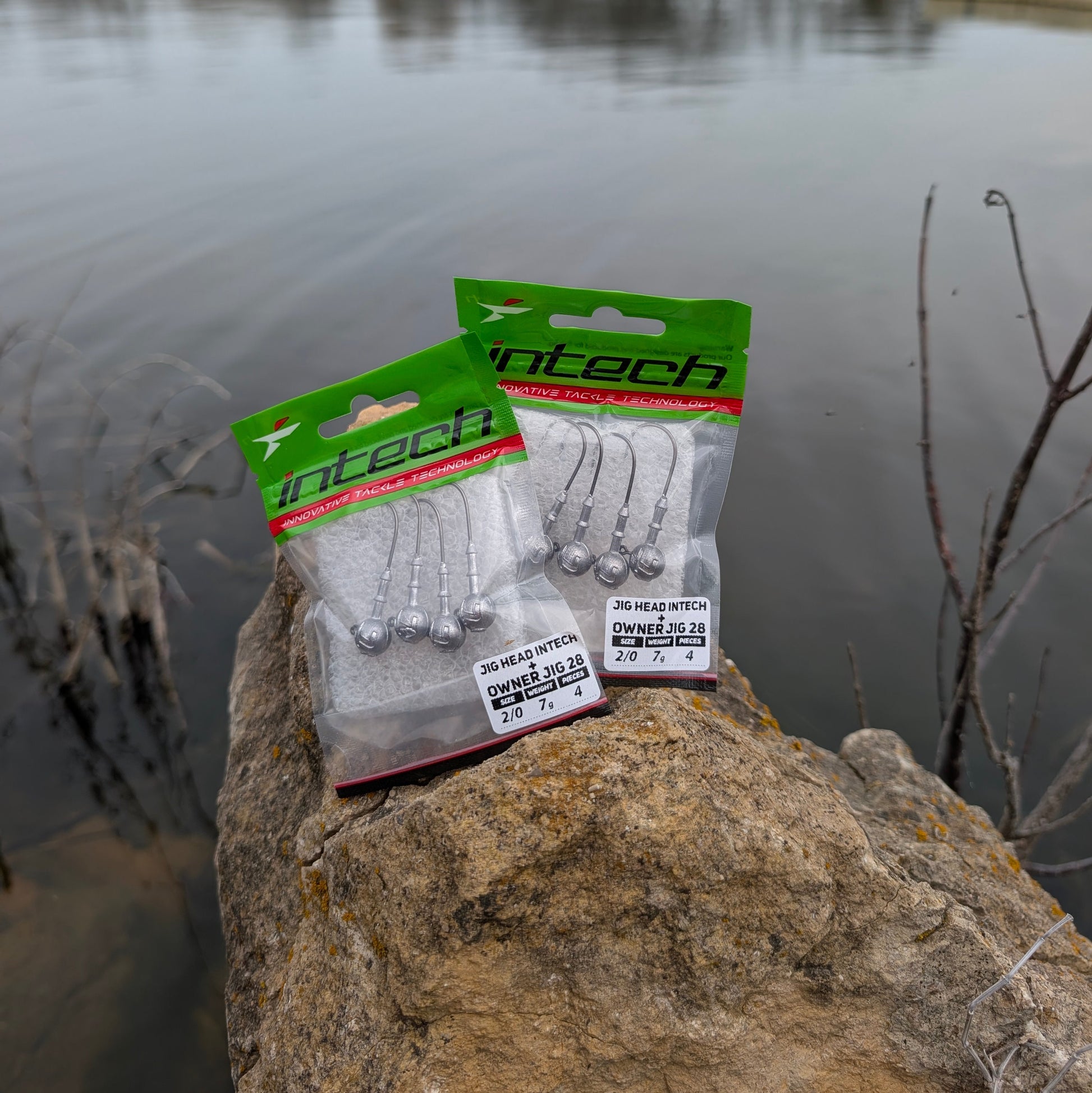Pack of Intech fishing hooks on a rock by a lake