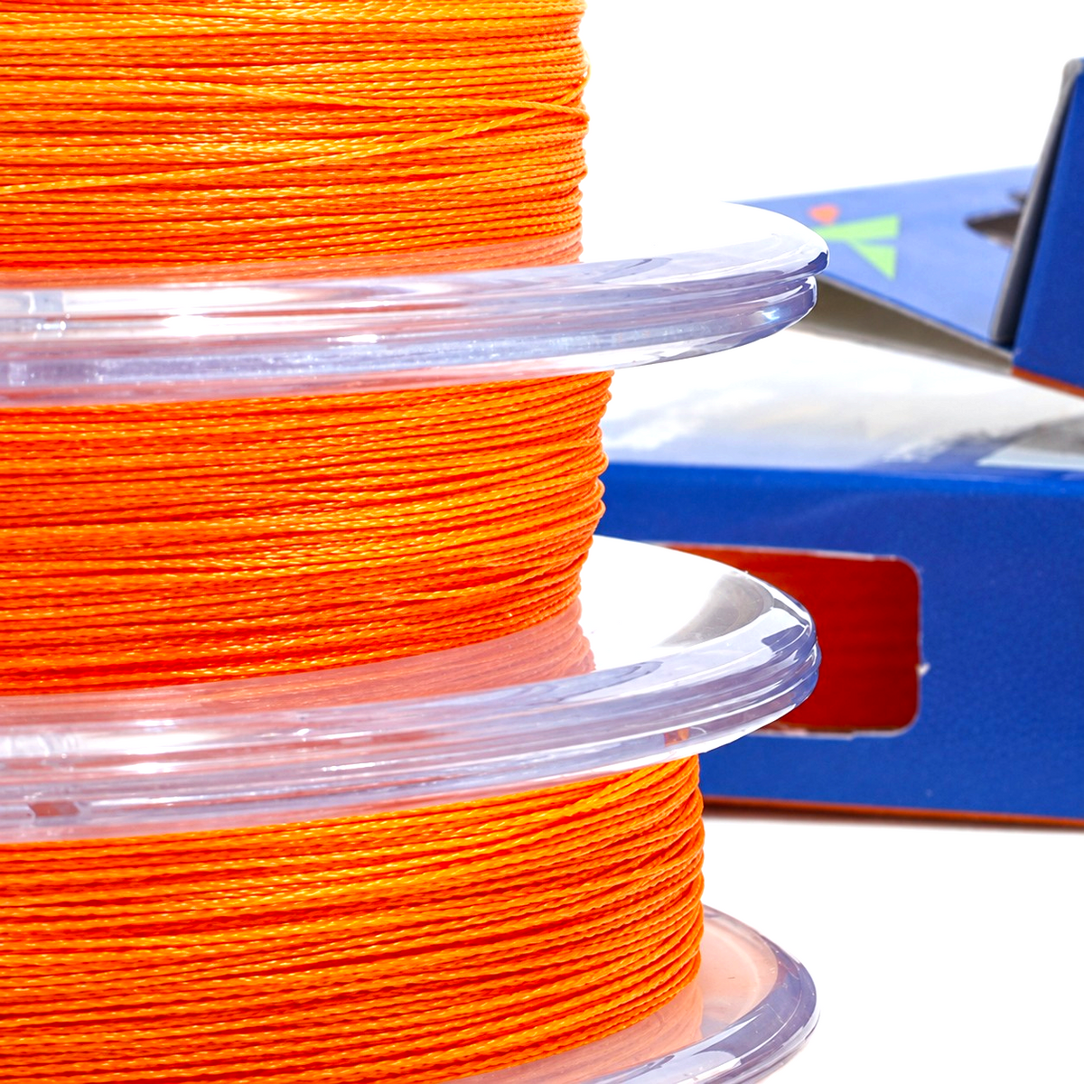 Close-up of three spools of Intech First Braid X4 Orange braided fishing line showing the braid texture.