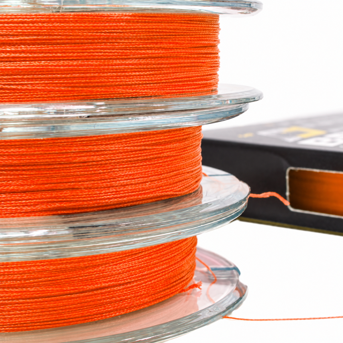 Close-up of orange Intech First Braid X8 braided fishing line wound on three stacked clear spools.
